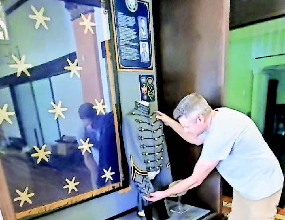 Creative Arts worker Dave Orlik installs an exhibit featuring the history of Kentucky Military Institute